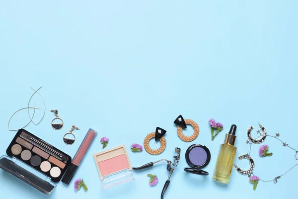 Makeup cosmetics with accessories on color background