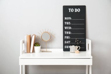 Gri duvarın yanında yapılacaklar listesi olan modern stil işyeri