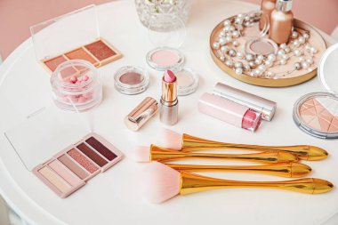 Makyaj fırçalarıyla makyaj masasında dekoratif kozmetik ürünler.