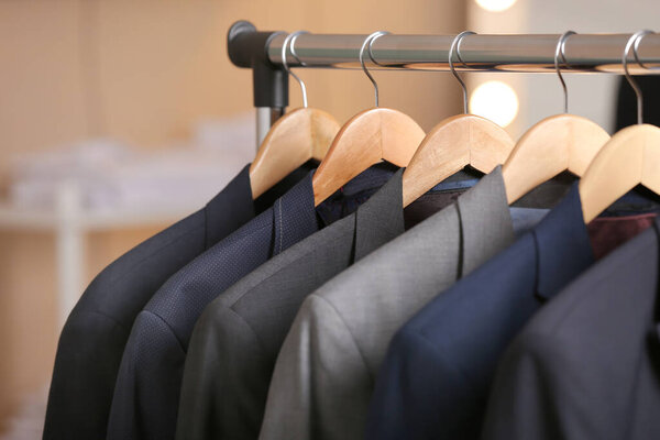 Hanger with different stylish male suits in store