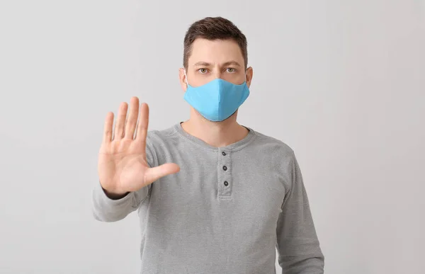 Man Skyddande Medicinsk Mask Visar Stop Gest Grå Bakgrund — Stockfoto