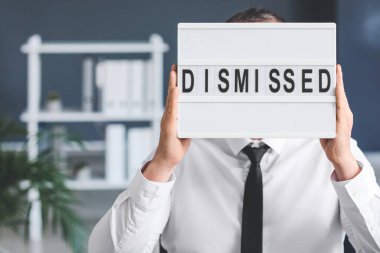 Yazılı panosu olan adam ofiste izinli.