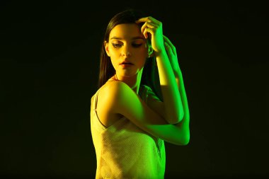 Koyu arkaplanda güzel bir genç kadının tonlu portresi.