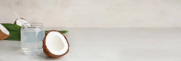 Mason jar of fresh coconut water on table with space for text