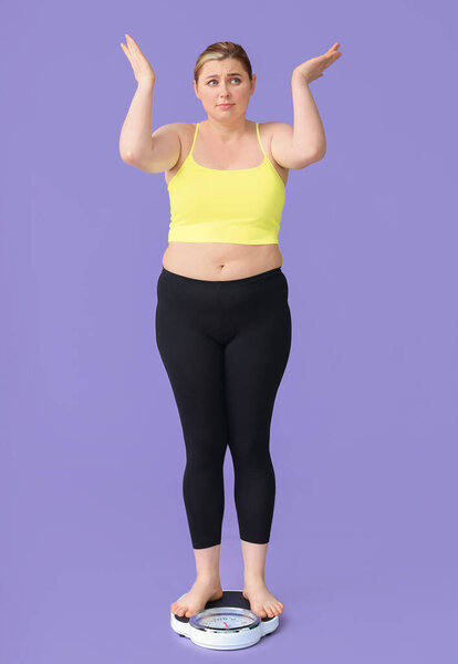 Displeased overweight woman on scales against color background. Weight loss concept