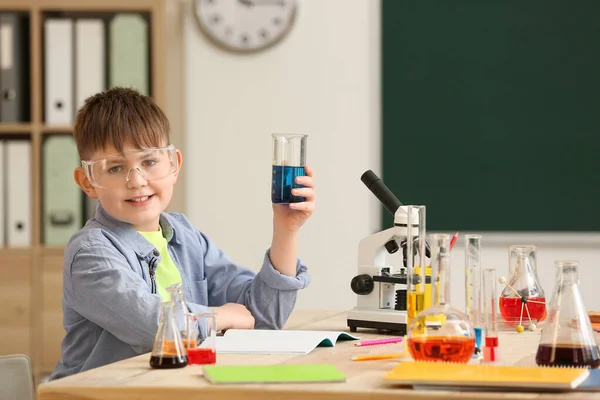 Cute little boy at chemistry lesson in classroom