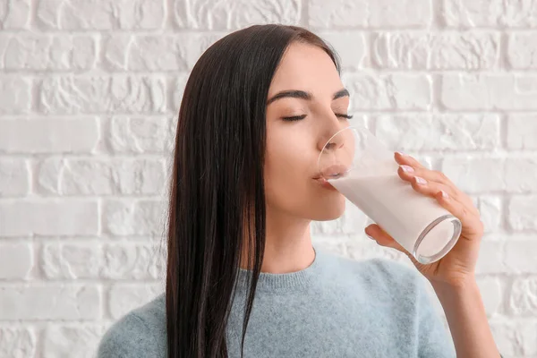 Schöne Junge Frau Trinkt Milch Auf Weißem Backsteinhintergrund — Stockfoto