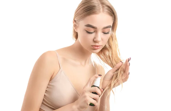 Ung Kvinna Som Använder Kosmetika För Hår Mot Vit Bakgrund — Stockfoto