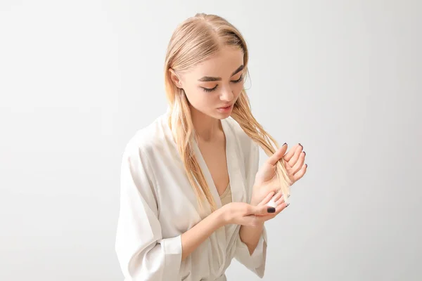白髪を背景に化粧品を使う若い女性 — ストック写真