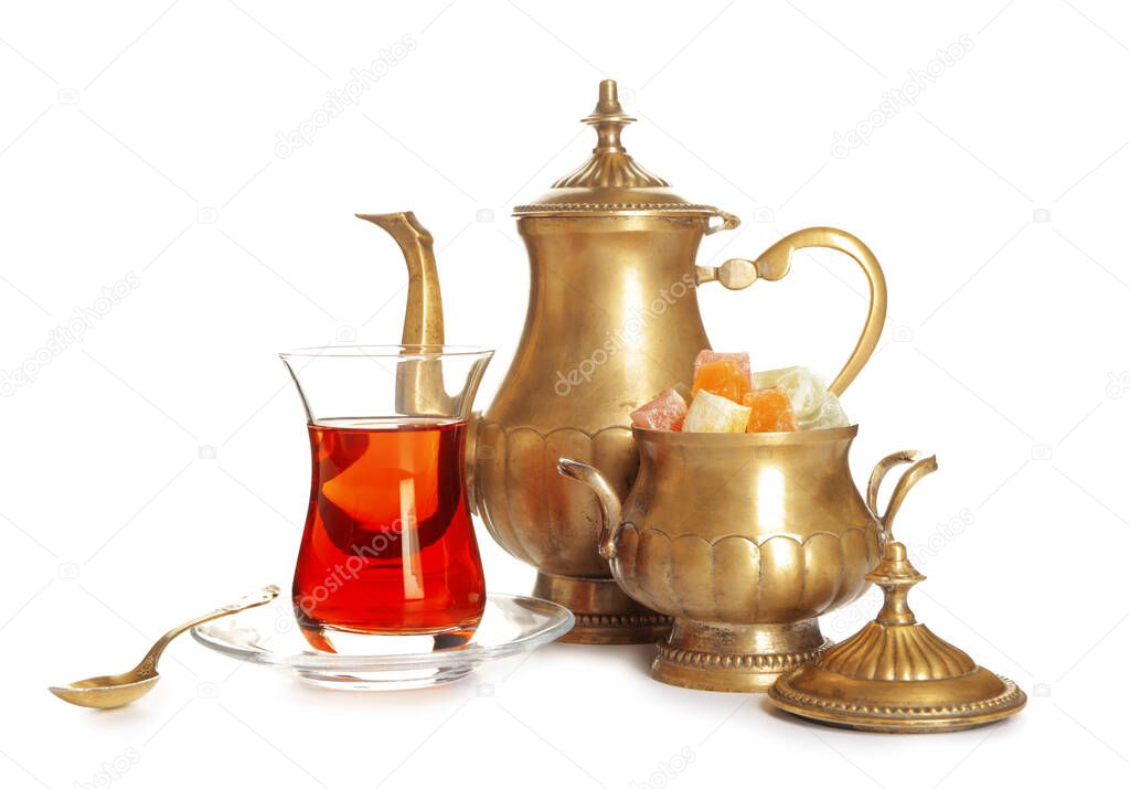 Tasty Turkish tea with sweets on white background