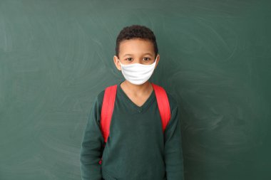 Sınıfta koruyucu maske takan sevimli Afro-Amerikan öğrenci. Salgın kavramı