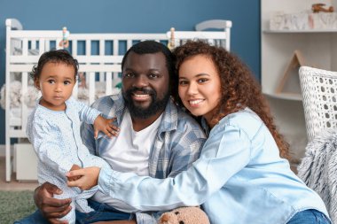Mutlu Afro-Amerikan ebeveynler ve evde şirin bir bebek