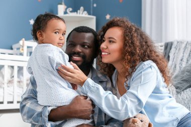 Mutlu Afro-Amerikan ebeveynler ve evde şirin bir bebek