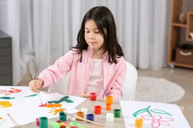 Evde resim yapan sevimli küçük bir kız.