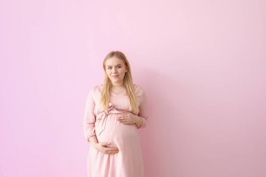 Renkli arka planda güzel hamile kadın