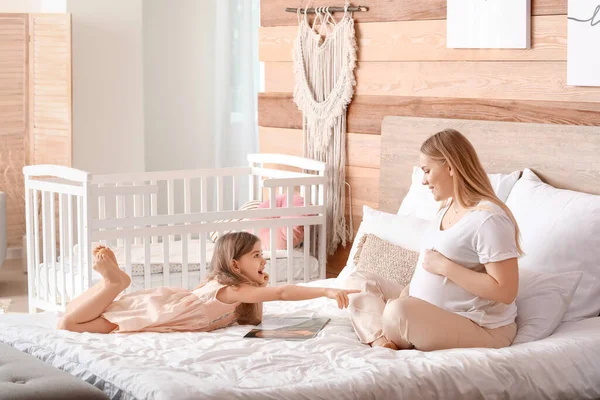 Beautiful Pregnant Woman Her Little Daughter Reading Book Bedroom — Stock Photo, Image