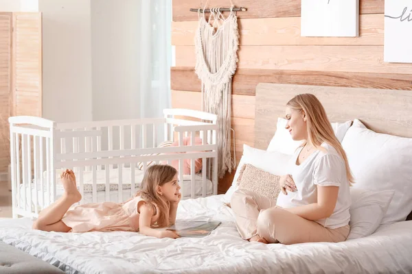 Beautiful Pregnant Woman Her Little Daughter Reading Book Bedroom — Stock Photo, Image