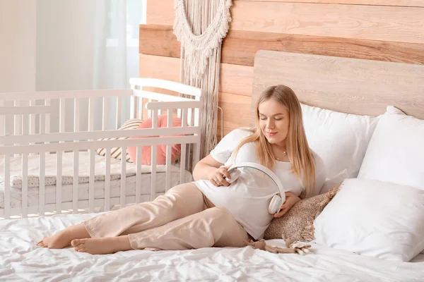 Hermosa Mujer Embarazada Poniendo Auriculares Vientre Dormitorio —  Fotos de Stock