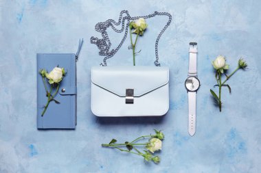 Renkli arka planda kol saati ve cüzdanı olan şık bir çanta