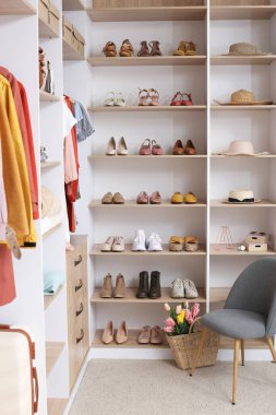 Soyunma odasında farklı giysiler ve aksesuarlar olan büyük bir gardırop.