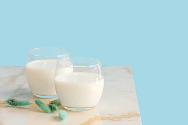 背景色を背景にミルクのテーブルの上のメガネ — ストック写真