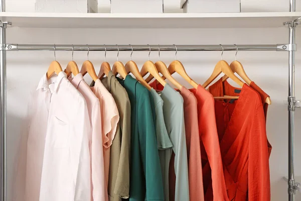 Stylish spring clothes on hanger in wardrobe