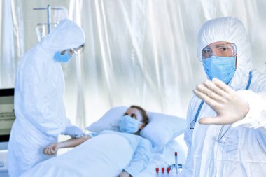 Biyolojik tehlike giysileri içindeki doktorlar bulaşıcı izolasyon koğuşundaki hastalarla çalışıyorlar. Coronavirüs salgını kavramı