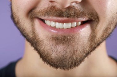 Handsome smiling young man on color background, closeup