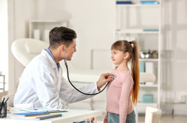 Pediyatrist küçük kızı klinikte muayene ediyor.
