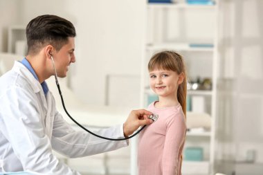 Pediyatrist küçük kızı klinikte muayene ediyor.