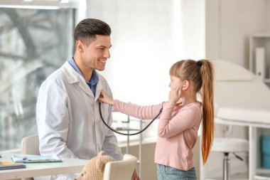 Küçük kız pediatrist ofisinde stetoskop ile oynuyor
