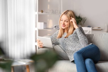 Evinde tablet bilgisayarı olan güzel bir kadın.