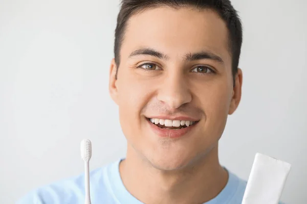 歯ブラシと光の背景にペーストを持つハンサムな男 — ストック写真
