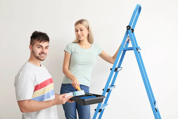 Pareja Joven Eligiendo Color Pared Sobre Fondo Blanco — Foto de Stock