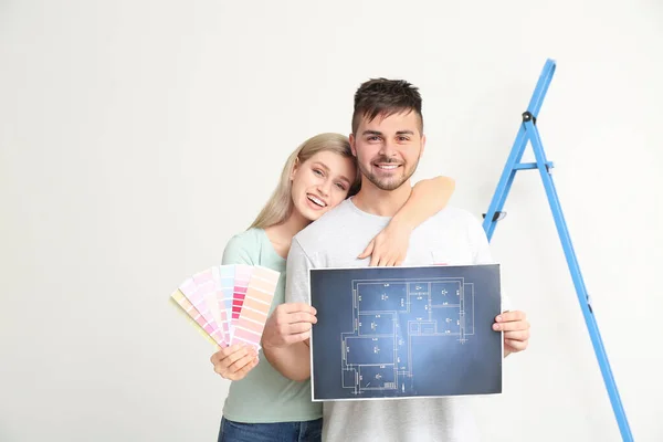 Junges Paar Mit Hausplan Und Farbmustern Auf Weißem Hintergrund — Stockfoto