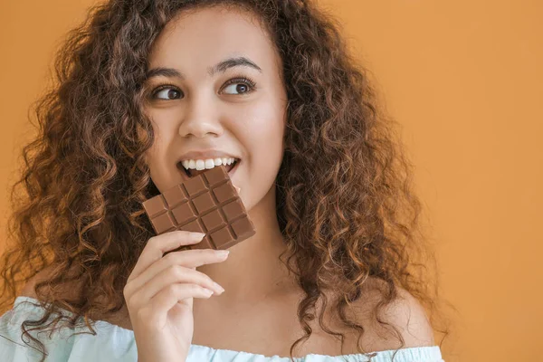 Junge Afrikanisch Amerikanische Frau Mit Schokolade Auf Farbigem Hintergrund — Stockfoto