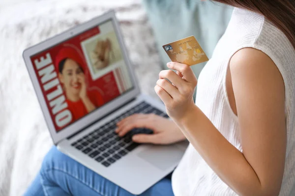 自宅にノートパソコンとクレジットカードを持つ若い女性 オンラインショッピングのコンセプト — ストック写真