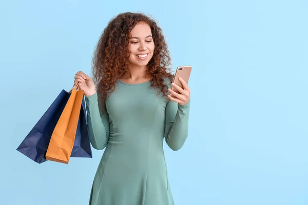 Mujer Joven Con Teléfono Móvil Bolsas Compras Fondo Color — Foto de Stock