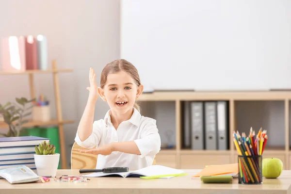 Милая Маленькая Школьница Поднятой Рукой Столом Классе — стоковое фото