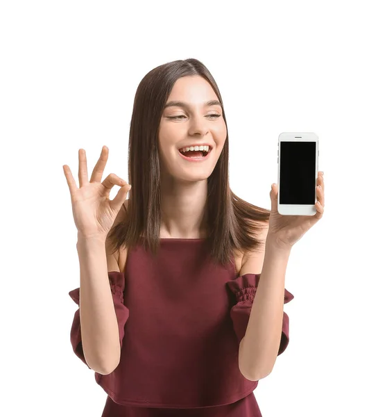 Krásná Mladá Žena Mobilním Telefonem Ukazuje Gesto Bílém Pozadí — Stock fotografie
