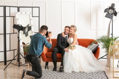 Photographer working with young wedding couple in studio