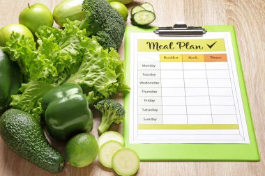 Ahşap zemin üzerinde sağlıklı ürünler ve yemek planı