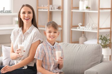 Anne ve küçük oğlu evde süt içiyorlar.