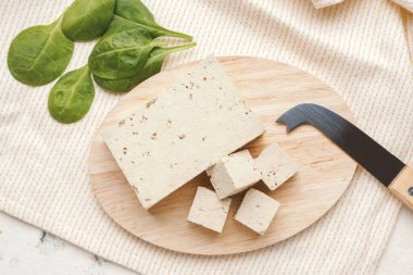 Masada lezzetli tofu peyniri olan bir tahta.