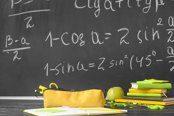 Pencil bag with stationery on desk in classroom