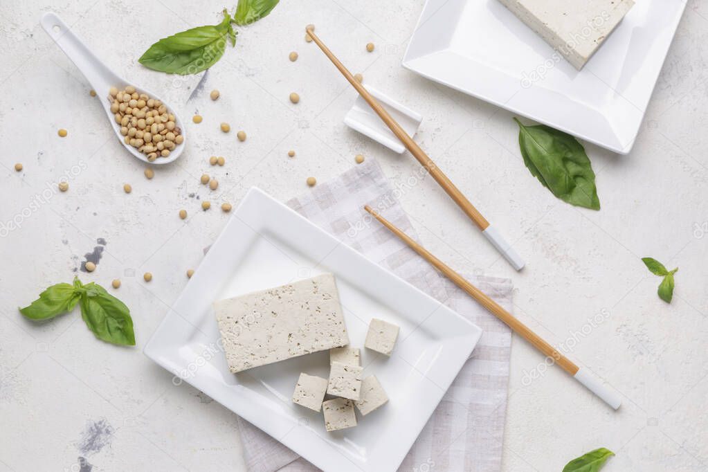 Plate with tasty tofu cheese and soy beans on white background