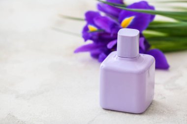 Beyaz arka planda çiçekli bir şişe parfüm.