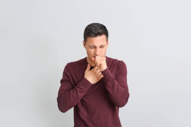 Hafif arka planda öksüren genç adam