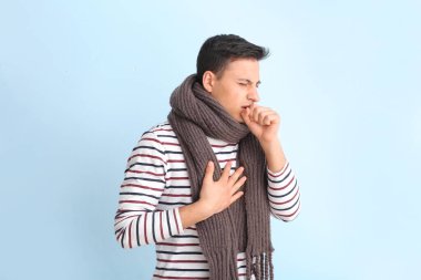 Hafif arka planda öksüren genç adam