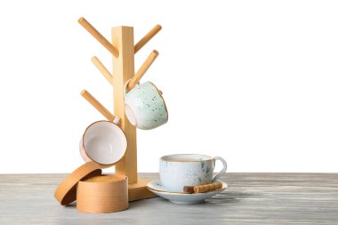 Beyaz arkaplana karşı masada fincanları olan tutucu